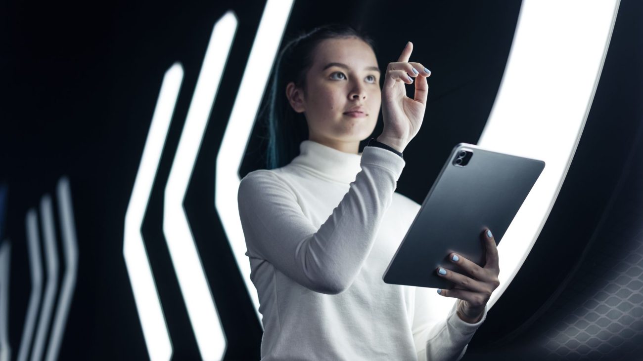 Empresaria colombiana analizando datos en tablet con tecnología de inteligencia artificial en oficina moderna