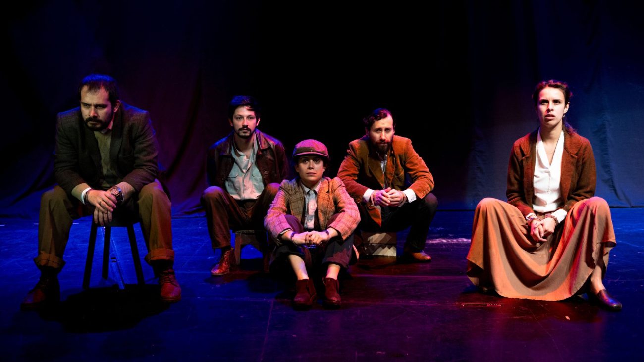 Elenco de "Muertos sin sepultura" de Jean-Paul Sartre en el Teatro Libre de Bogotá. Cinco actores representando a miembros de la Resistencia francesa en escena con iluminación dramática azul y púrpura.